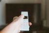 person setting up smart TV at home remote control