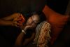 person watching television while using smartphone on couch